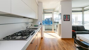 Une cuisine moderne équipée d’une cuisinière à gaz, d’un évier et offrant une vue sur le salon.