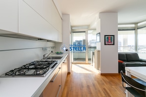 Eine moderne Küche mit Gaskochfeld, Spüle und Blick zum Wohnbereich.