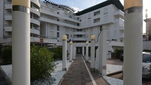 Un hôtel à plusieurs étages doté d’une cour intérieure, de colonnes blanches et d’une allée pavée.