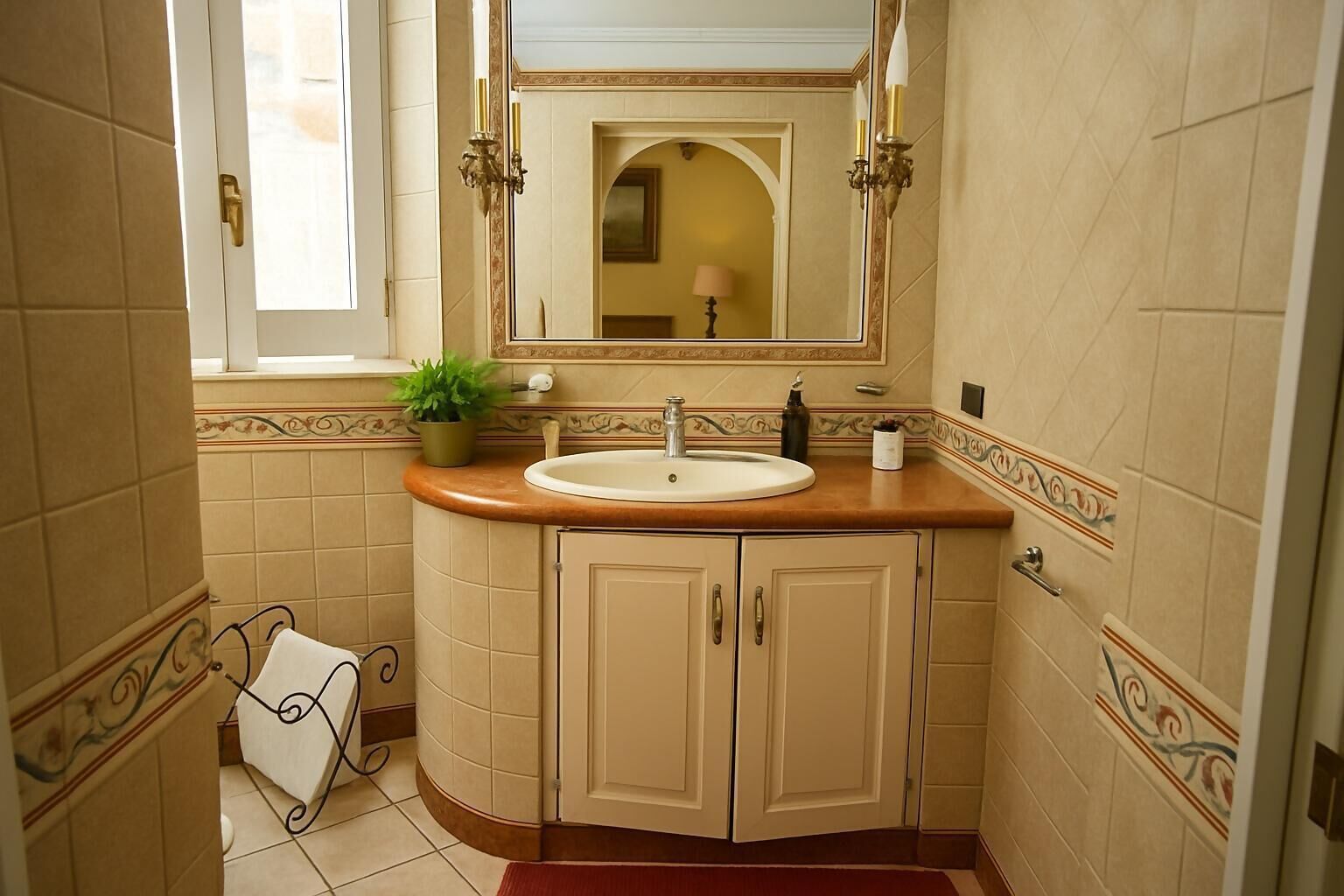 Un baño con lavamanos, espejo y armarios.