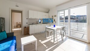 Un appartamento moderno con cucina, zona pranzo e un balcone vista città.