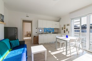 A modern apartment with a living area, kitchen, and dining space. - Laguna Park °Pool°- 05 (Lido di Jesolo)