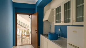 Una cocina con un refrigerador blanco, una cesta azul y una estufa.