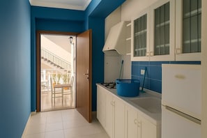 A kitchen with a white refrigerator, a blue basket, and a stove. - Vacation Home Mother Angela (Letojanni)