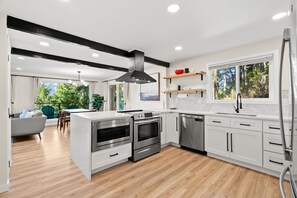 Una cocina moderna con electrodomésticos integrados, un comedor con vistas y una sala de estar con sofá.