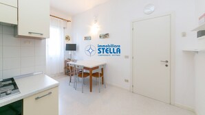 Ett kök med ett matbord, stolar och en väggmonterad lampa.