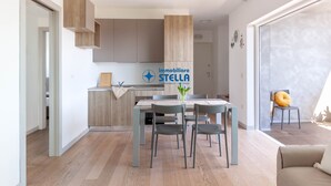 Ett modernt kök med träskåp, ett matbord med stolar och en skylt med texten ”immobiliare STELLA”.