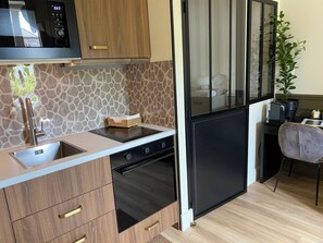 A compact kitchen with a built-in oven, a sink, and a microwave. - Cozy and in a great location  (Dijon)