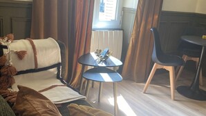 Een gezellige kamer met een bank, een klein tafeltje en een stoel.