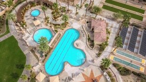An aerial view of a resort with multiple swimming pools, a star-shaped sun patio, and a parking area. - Cozy 1-bedroom condo with AC in soothing Palm Desert (Palm Desert)