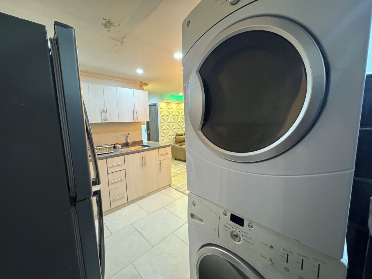 Una cocina equipada con lavadora, refrigerador y pileta.