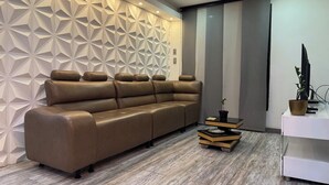A modern living room with a sectional sofa, a geometric wall design, and a minimalist wooden coffee table. - HERMOSO APARTAMENTO EN LAURELES ESTADIO (Medellín)