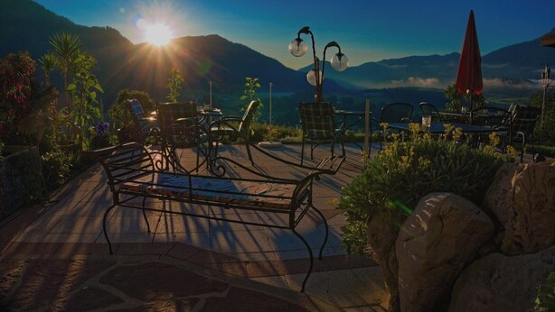 Un patio con mobiliario exterior, una lámpara decorativa y vistas a las montañas.