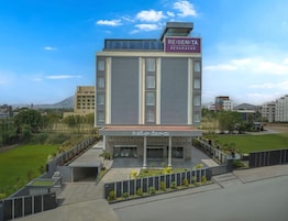 Un moderno edificio de hotel con un letrero que dice 'RE:GEN:TA DEVARAYAH' y una zona de acceso cubierta.