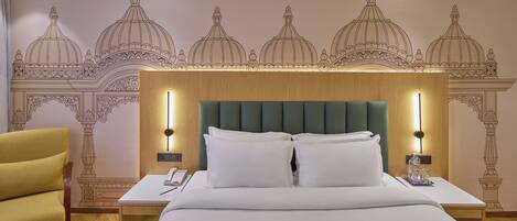 A hotel room with a large bed, two bedside tables, a nightstand, a chair, and a wall with a decorative pattern.