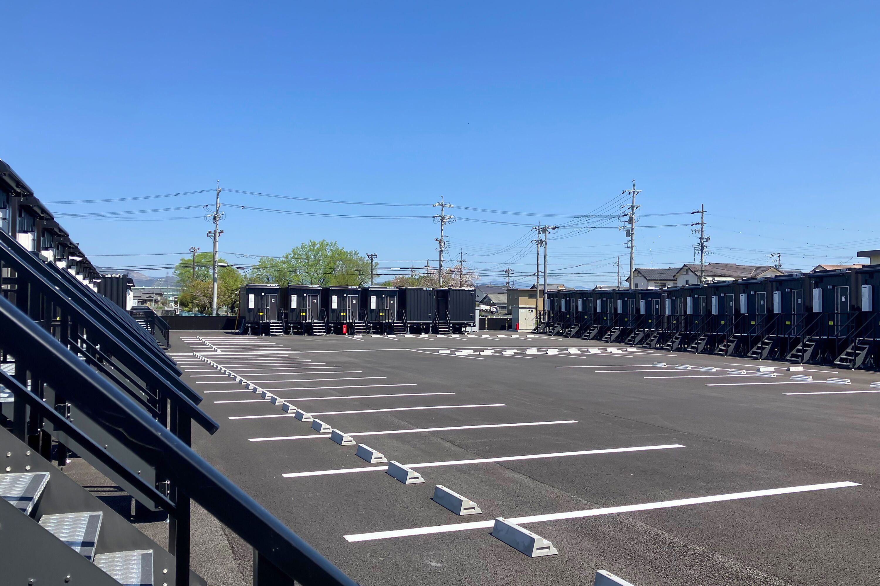 Un estacionamiento con espacios delimitados y un edificio al fondo.