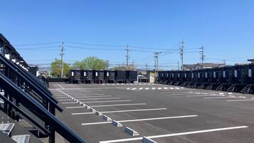 Un estacionamiento con espacios delimitados y un edificio al fondo.