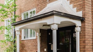 A brick building with a white entrance canopy, a door, and a window. - The Rockley Sunlit Urban Apartment in South Yarra (South Yarra)