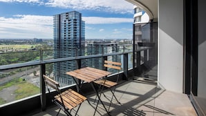 Un balcone con vista su un paesaggio urbano, con edifici moderni e un binario ferroviario.