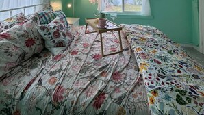 Una habitación con cama, ventana y vistas al exterior.