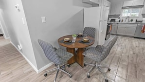 A modern kitchen with white cabinets, a built-in oven, and a window with blinds. - 4BR Workspace Home | 2.5 Baths | Sleeps 8 (Houston)