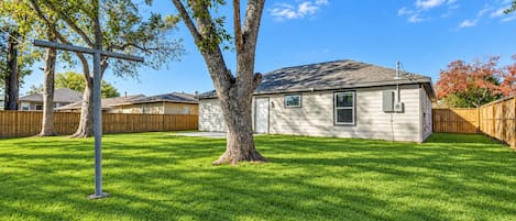 Il s’agit d’une propriété résidentielle dotée d’une pelouse bien entretenue, d’une maison de plain-pied et d’une clôture en bois.