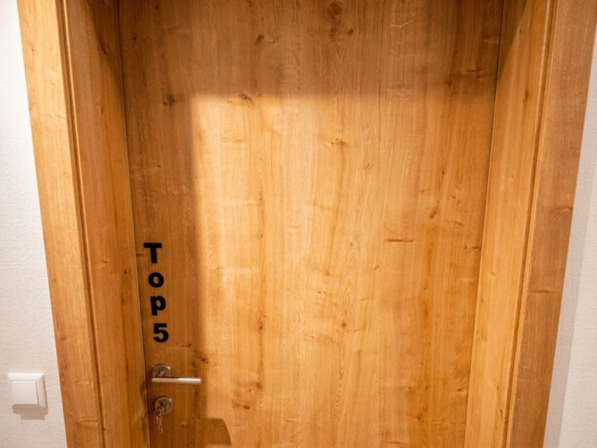 Eine Holztür mit der Aufschrift 'TOP 5'.