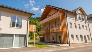 Un immeuble moderne à deux étages, doté d’un balcon au rez-de-chaussée et d’un autre balcon à l’étage supérieur.