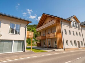 Ein modernes, zweistöckiges Gebäude mit einem Balkon im Erdgeschoss und einem Balkon im zweiten Stock.