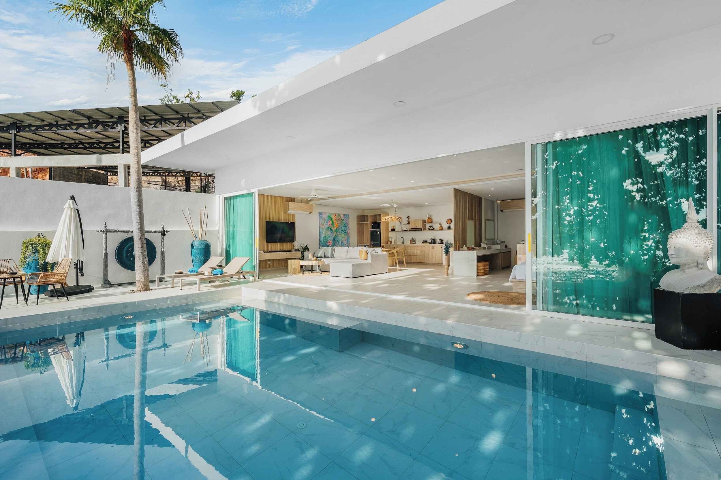 Un área de piscina moderna con vista despejada al espacio de estar contiguo, que incluye una cocina y comedor.