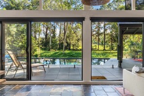 A modern house with large glass doors leading to a pool and garden. - Mabel Perfect Noosa Hinterland Gem w/ Heated Pool (Hinterland Region)