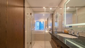 A modern bathroom with a glass shower enclosure, a large mirror, and a dual sink vanity. - Panorama Luxury Hotel - Full Services (Nha Trang)