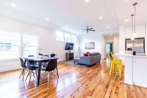 A spacious living area with a dining table, sofa, and yellow chairs. - Your Comfy Bungalows! Sleeps 30/12BR/8BA/16PA (Houston)