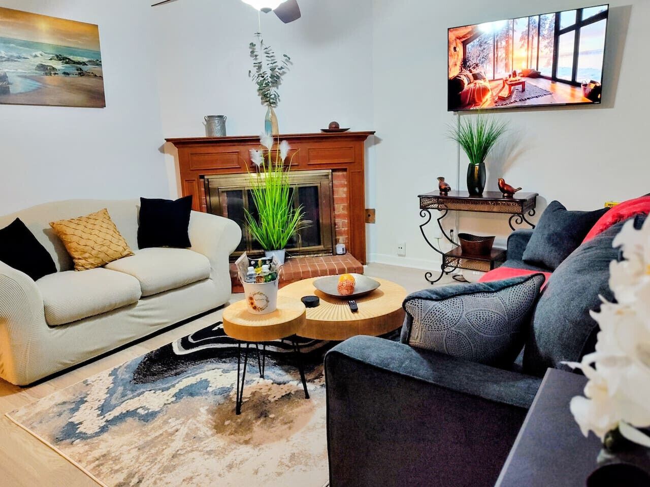 A living room with a fireplace, a sofa, a coffee table, and a TV mounted on the wall.