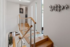 A staircase with wooden steps and metal railings leading to an upper floor. - Modern, Airy Duplex Steps to River w/ Heated Pool (Noosa Region)