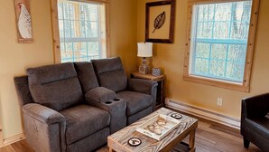 A living room with a grey sofa, a wooden coffee table with a decorative tray, and two windows with blinds. - Brand New! Bright, Airy Cabin Boarding Winslow Hill Elk Viewing Area! (Benezette)