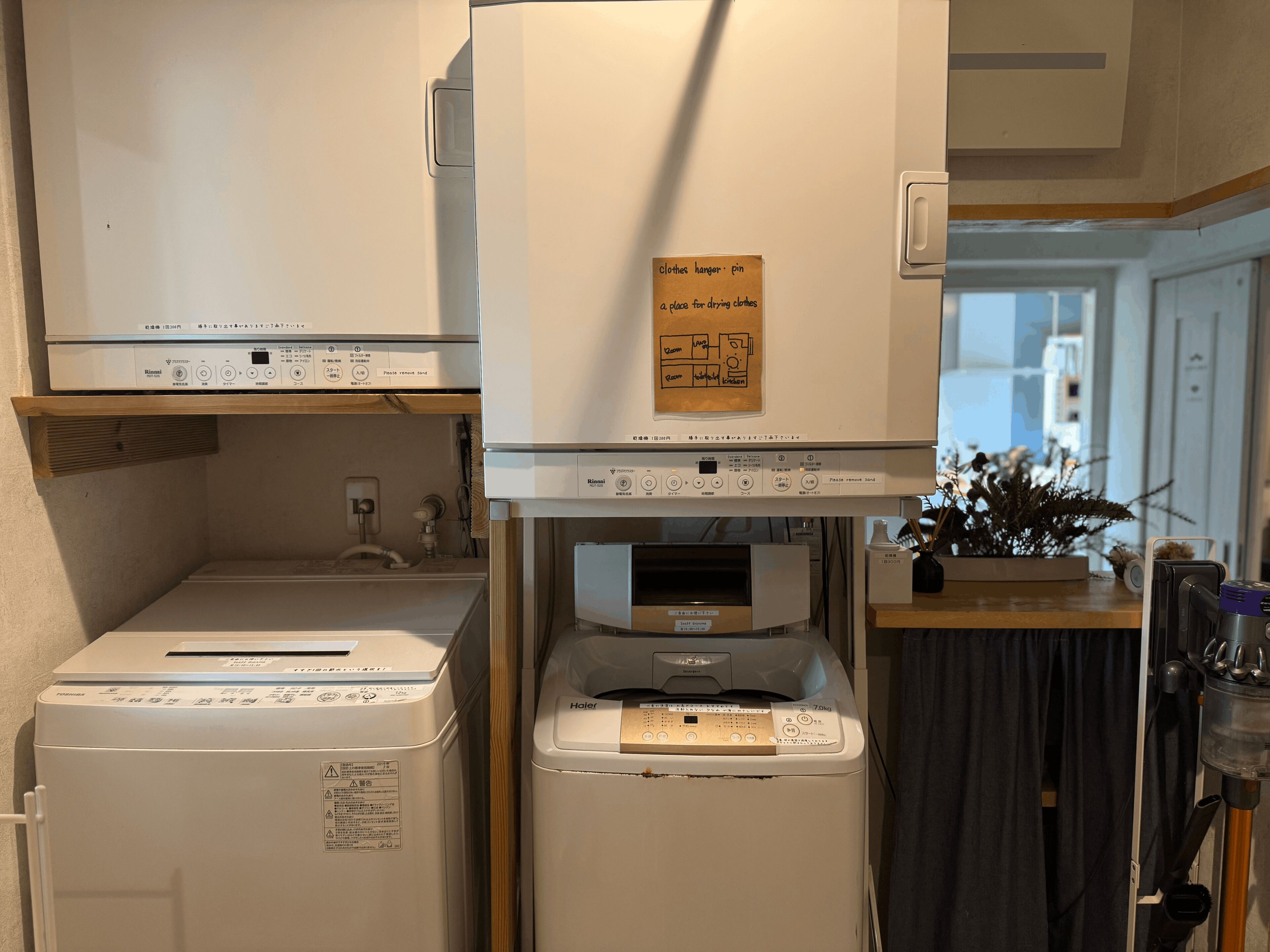 A laundry area with a clothes hanger pin sign, a washing machine, and a dryer.