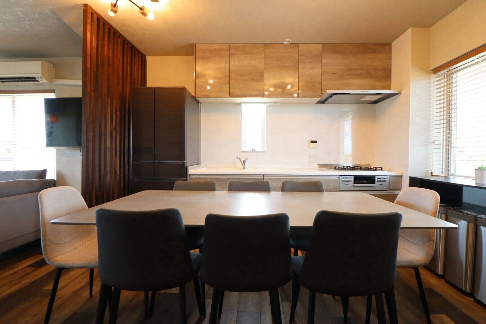 Uma cozinha moderna com uma mesa de jantar e cadeiras, armários embutidos e um fogão.
