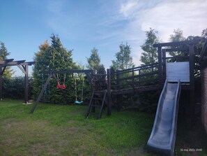 Ein Spielplatz mit Rutsche und Schaukeln.