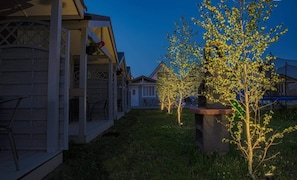 Un barrio residencial con casas, un porche y un pequeño árbol con luces.