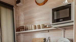 A compact kitchen with a microwave, a small sink, and a dish rack. - Holiday Home in Dziwnowek by Baltic Sea (Kamien Pomorski)