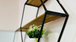 A geometric wall-mounted shelf with two levels, each holding a potted plant. - Apartment no. 5 (Antsiranana)