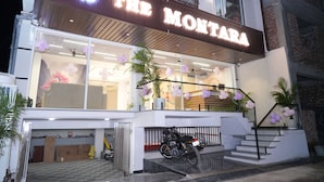 Ein Gebäude mit einem Schild, auf dem 'THE MONTARA' steht, und einem Motorrad davor geparkt.