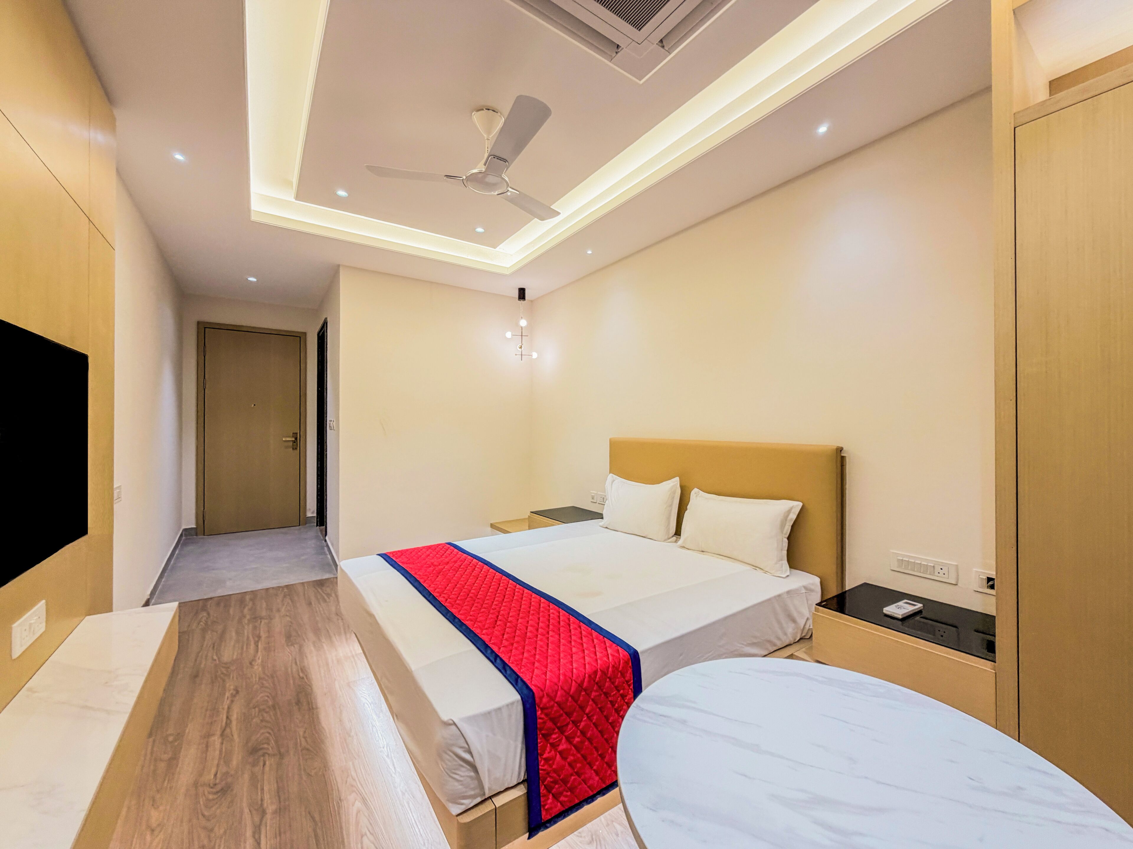 A hotel room with a bed, bedside table, and a ceiling fan.