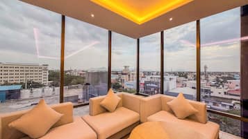 Un interior moderno con un conjunto de sofás y ventanas amplias que ofrecen vistas de la ciudad.