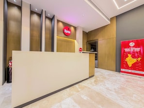 A reception desk with a Spree logo, a 'HELLO!' sign, and a Spree promotional poster.