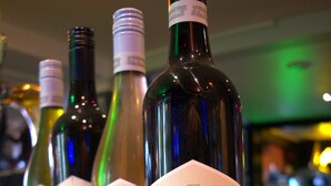 A row of wine bottles with labels on a bar counter. - The Imperial Hotel (Cowra)