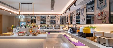 A modern restaurant interior with a central counter, decorative elements, and a clean, well-lit environment.