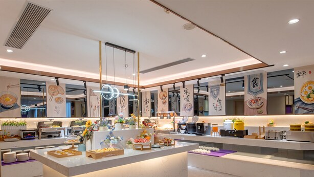 Una cocina moderna con una isla central, diversos electrodomésticos y detalles decorativos.