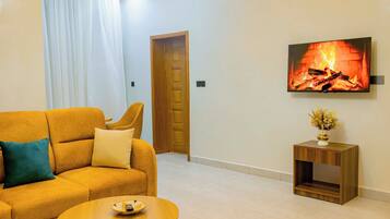 Deluxe Apartment | Living area | 42-inch flat-screen TV with digital channels
